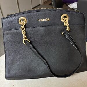 Calvin Klein Black and Gold Shoulder Bag with protective bag for storage.